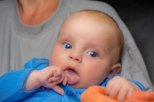 Adjusting to Life as New Parents After Adoption Blog Image. A closeup of a baby with bright blue eyes.