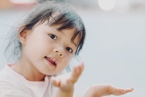 Should an Adopted Child Know Their Biological Parents? article image: A young girl about 4 years old looking over her shoulder at the camera.
