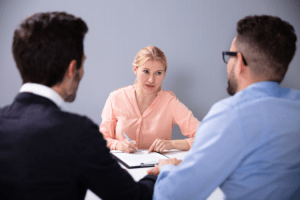 Two potential fathers sit with an adoption counselor to discuss the adoption process.